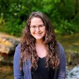 Nature image of woman posing in front of creek